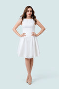 White sleeveless fit-and-flare dress with a wide neckline, fitted waist, and short skirt, shown from the front in a pale grey studio.